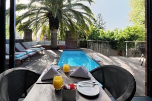 a table and chairs with a table and a swimming pool at The Tree House Boutique Hotel by The Living Journey Collection in Cape Town