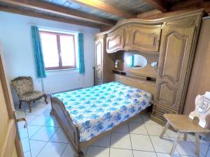a small bedroom with a bed and a chair at Appartement de 2 chambres avec jardin amenage et wifi a Soultzeren a 3 km des pistes in Soultzeren