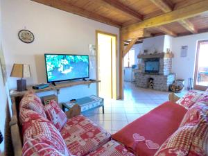 a living room with a couch and a flat screen tv at Appartement de 2 chambres avec jardin amenage et wifi a Soultzeren a 3 km des pistes in Soultzeren