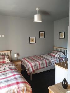 a bedroom with two beds and a table and a lamp at Lovely 4 bed house sleeping 8 near Ashbourne in Brassington