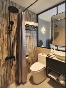 a bathroom with a toilet and a sink and a shower at The Seraya Hotel in Kota Kinabalu