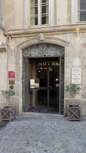 una entrada de hotel con dos macetas delante en Hôtel du Palais des Papes, en Aviñón