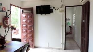 a room with a door and a tv on a wall at Appartement cosy au Robert - 28 m² avec jardin sublime in Le Robert