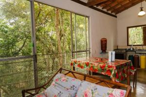 a living room with a table and a couch at Chalés do Beto em Macacos in Macacos