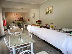 a restaurant with a long counter with tables and chairs at Maranim Plaza Hotel in Amparo