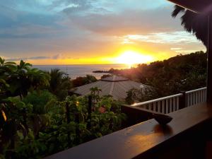 ブイヤントにあるBungalow de 2 chambres a Bouillante a 100 m de la plage avec vue sur la mer jardin amenage et wifiの家のバルコニーからの夕日