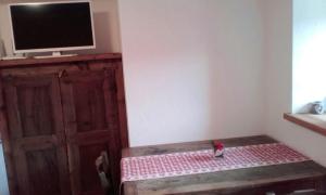 una habitación con TV sentada en una mesa junto a una puerta en One bedroom chalet with enclosed garden and wifi at Planaz, en Fontainamore