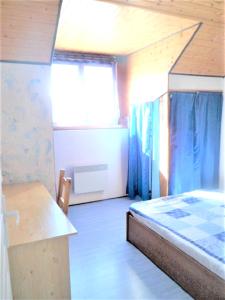 SelonnetにあるAppartement de 3 chambres avec piscine partagee et balcon amenage a Selonnetのベッドとデスクが備わる小さな客室です。
