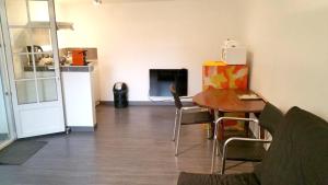 - un salon avec une table et un réfrigérateur dans l'établissement Studio avec wifi a Saint Ay, à Saint-Ay