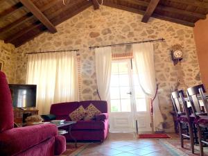 uma sala de estar com um sofá roxo e uma porta em 3 bedrooms house with enclosed garden and wifi at Aldehuela de la Boveda em Aldehuela de la Bóveda