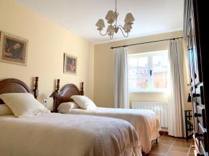 a bedroom with two beds and a window at 3 bedrooms house with enclosed garden and wifi at Aldehuela de la Boveda in Aldehuela de la Bóveda