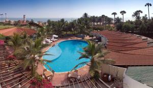 an aerial view of a resort swimming pool with palm trees at The Park Visakhapatnam in Visakhapatnam