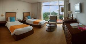 a hotel room with two beds and a desk at The Park Visakhapatnam in Visakhapatnam