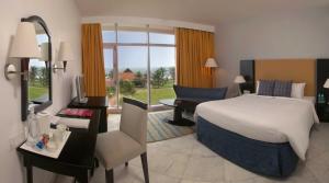 a hotel room with a bed and a desk and a chair at The Park Visakhapatnam in Visakhapatnam