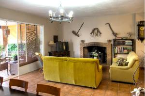 sala de estar con sofá amarillo y chimenea en 5 bedrooms villa with private pool jacuzzi and furnished terrace at Mirandilla, en Mirandilla