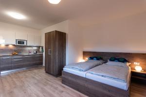 a bedroom with a large bed and a kitchen at Tatry Panorama in Pavčina Lehota