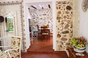 ein Esszimmer mit einem Tisch und einer Steinmauer in der Unterkunft Charming house in Estivella near nature in Estivella