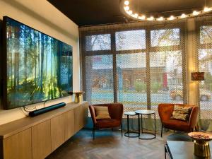 a living room with two chairs and a large tv at Hotel Zeitgeist in Warburg