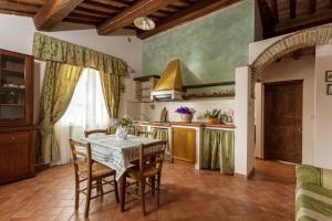 a kitchen with a table and chairs in a room at Charming Apartment in Montepulciano 45m² with shared pool in Montepulciano