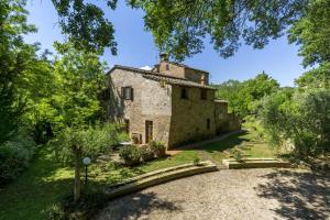 an external view of a stone house with trees at Charming Apartment in Montepulciano 45m² with shared pool in Montepulciano