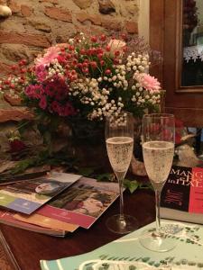 two glasses of champagne on a table with a vase of flowers at Charming Apartment in Montepulciano 45m² with shared pool in Montepulciano +19 photos