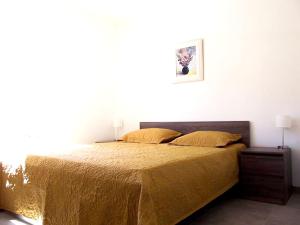 1 dormitorio con cama con colcha de oro en Maison de 4 chambres avec piscine privee jardin amenage et wifi a La Roche sur le Buis, en La Roche-sur-le-Buis