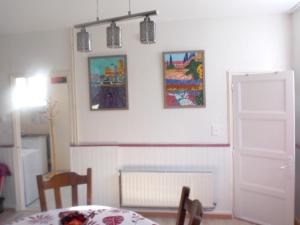 SourdevalにあるMaison de 2 chambres avec jardin clos et wifi a Sourdevalのダイニングルーム(テーブル付)が備わります。壁には絵画が飾られています。