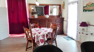 ein Esszimmer mit einem Tisch, Stühlen und einem Spiegel in der Unterkunft Maison de 2 chambres avec jardin clos et wifi a Sourdeval in Sourdeval