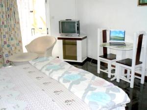 a bedroom with a bed and a tv and a laptop at Studio with city view furnished balcony and wifi at Trou aux Biches 1 km away from the beach in Trou aux Biches