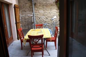 une table avec quatre chaises et un chiffon de table jaune dans l'établissement Maison de 3 chambres avec jardin clos et wifi a Nuits Saint Georges, à Nuits-Saint-Georges