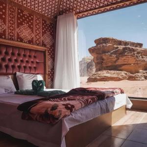 a bedroom with a bed with a view of the desert at Wadi Rum Dream Camp in Wadi Rum