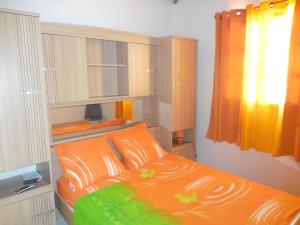 a bedroom with an orange bed with orange pillows at Maison de 2 chambres avec jardin clos et wifi a Sainte Anne a 3 km de la plage in Sainte-Anne