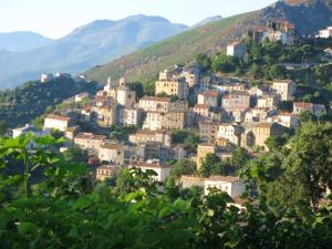 un pueblo en una colina con montañas en el fondo en Maison confortable avec vue sur la mer et la montagne à Oletta., en Oletta 15 fotos más