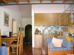a living room with a blue couch and a staircase at 2 bedrooms house at Albufeira 400 m away from the beach with furnished garden in Albufeira