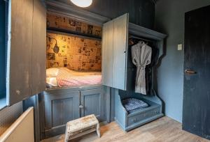 a wooden cabinet with a bed in a room at Smederij Texel in De Cocksdorp