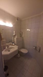y baño con aseo blanco y lavamanos. en Landhaus Sonnrain, en Saalbach Hinterglemm