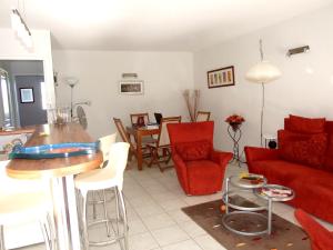 uma sala de estar com um sofá vermelho e uma mesa em Appartement de 2 chambres a Frejus a 800 m de la plage avec piscine partagee terrasse amenagee et wifi em Fréjus