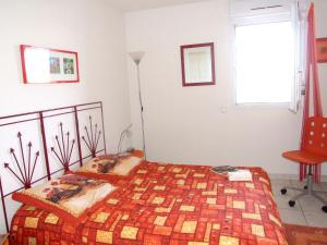 フレジュスにあるAppartement avec terrasse à Fréjus, 70 m², piscine partagéeのベッドと椅子と窓のある寝室