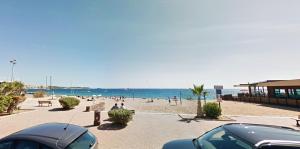 uma praia com pessoas na areia e no oceano em Appartement de 2 chambres a Frejus a 800 m de la plage avec piscine partagee terrasse amenagee et wifi em Fréjus