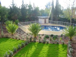 フレジュスにあるAppartement avec terrasse à Fréjus, 70 m², piscine partagéeのヤシの木が茂る庭園内のスイミングプール +5枚の写真