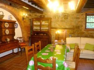 a dining room with a green table and a couch at Elegant Villa in Tuoro sul Trasimeno with Private Pool in Tuoro sul Trasimeno