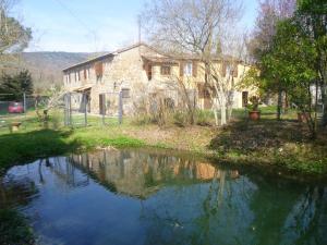 a stone house with a river in front of it at Elegant Villa in Tuoro sul Trasimeno with Private Pool in Tuoro sul Trasimeno