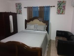 a bedroom with a bed and a couch at Lovely 4-Bed House in beautiful Portland in Buff Bay