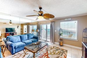 a living room with a blue couch and a ceiling fan at Island Echos 7th Floor Condos in Fort Walton Beach