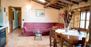 a living room with a red couch and a table at 3 bedrooms appartement with shared pool enclosed garden and wifi at Caprese Michelangelo in Arezzo