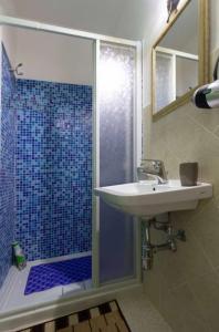 un bagno con lavandino e doccia con porta in vetro di Studio with city view balcony and wifi at Castelbuono a Castelbuono