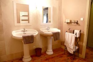 La salle de bains est pourvue de 2 lavabos, d'un miroir et de serviettes. dans l'établissement Villa spacieuse et charmante à Saint-Gilles avec piscine privée, à Saint-Gilles 28 autres photos