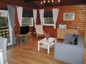 ein Wohnzimmer mit einem Sofa und einem TV in der Unterkunft Lärchenallee 77 in Isenbüttel