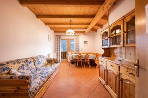 a living room with a couch and a table at Villa Mazzel with balcony in Vigo di Fassa