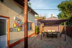 un patio con mesa y cenador en 3 bedrooms house at Constanta 500 m away from the beach with enclosed garden and wifi, en Constanţa